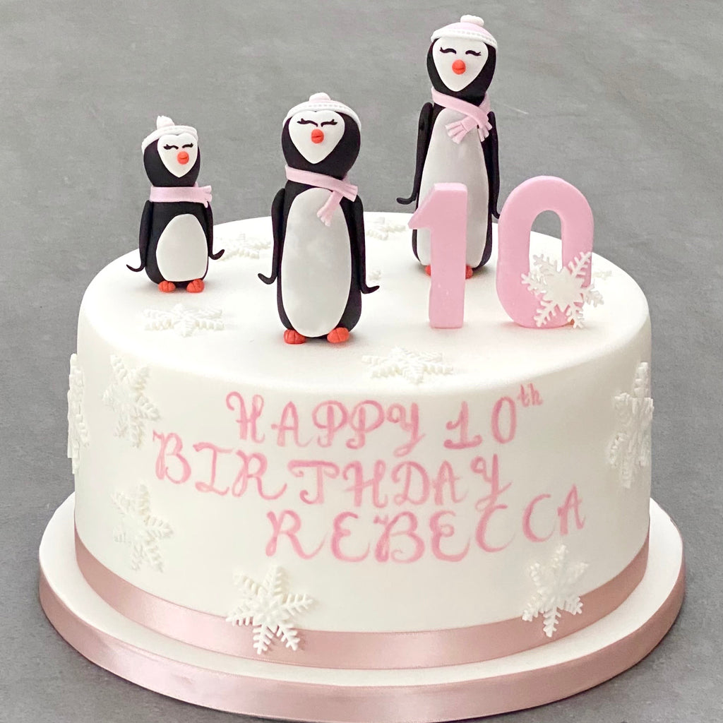Birthday cake with penguin decorations and 'Happy Birthday Message' text on a gray background